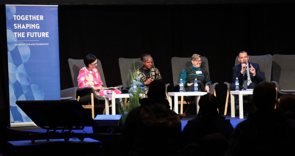 four school administrators facilitating a panel on a stage