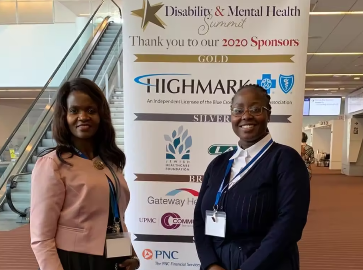 Two Fulbright Teachers standing by a banner