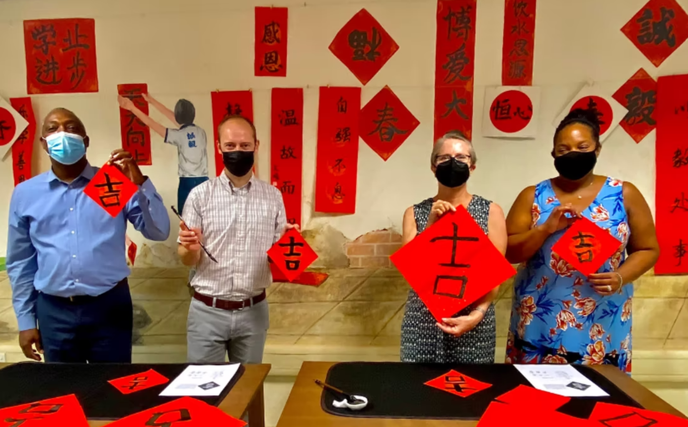 four teachers in Singapore holding up Chinese calligraphy