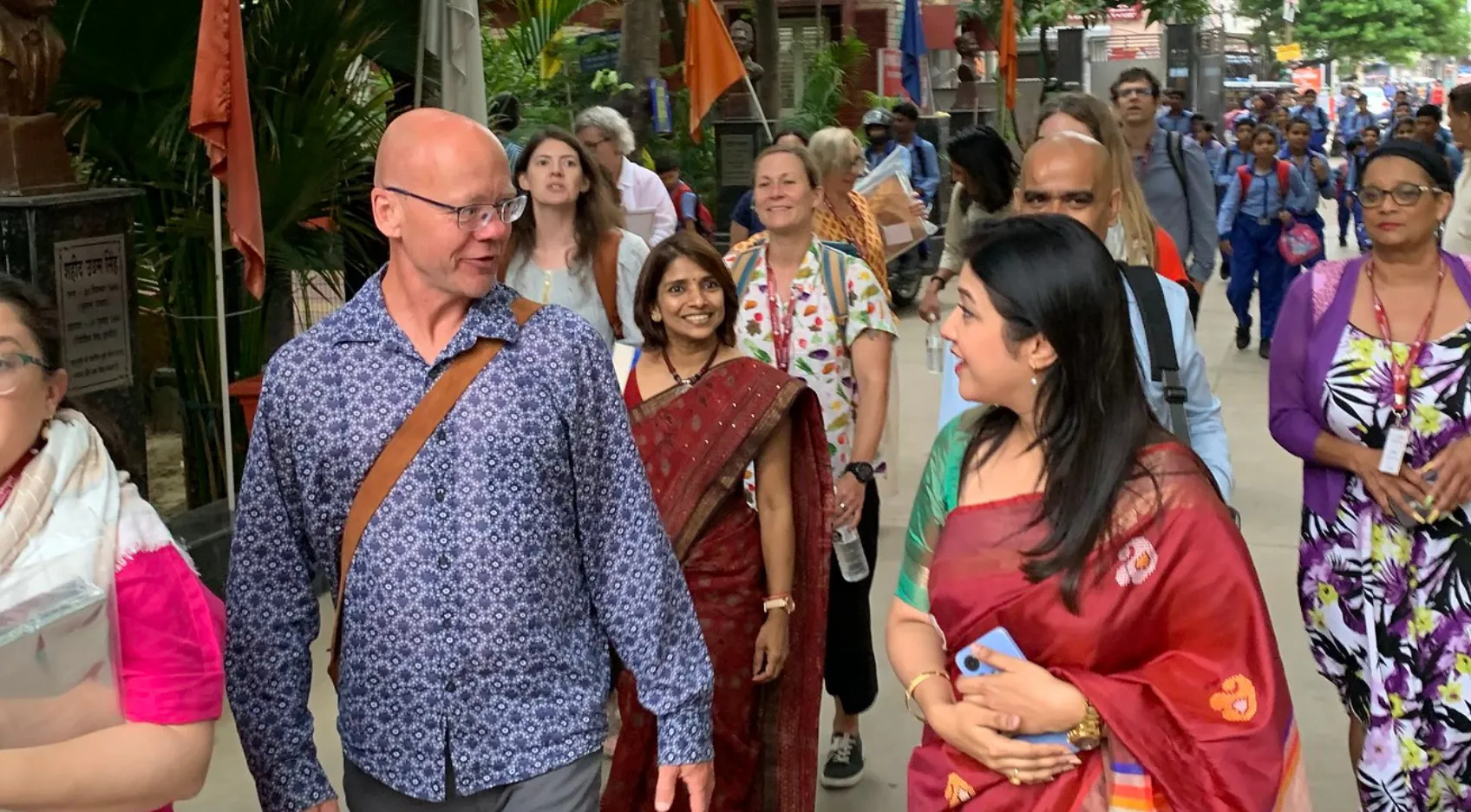 Two teachers in conversation outside a school