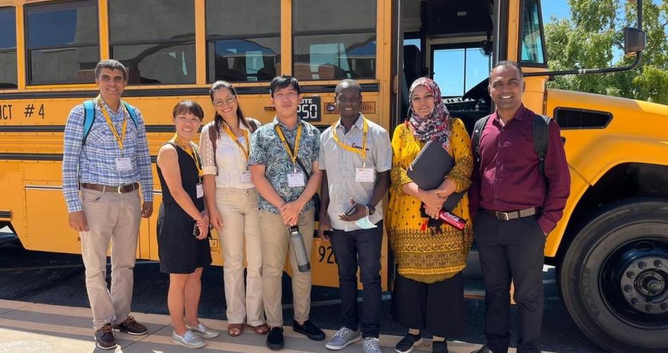international Fulbright Teachers at Arizona State University standing in front of a school bus